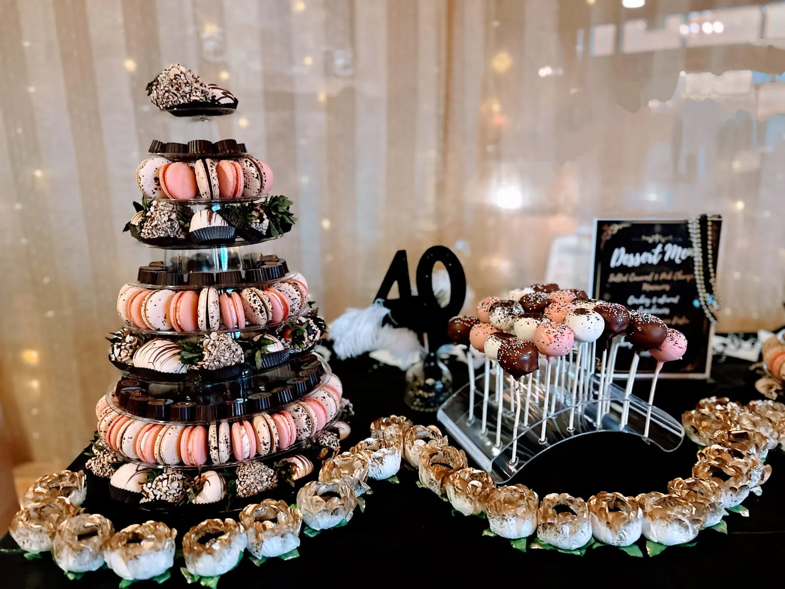 A birthday Event Tower beside a 40th-birthday dessert table of cake pops and treats