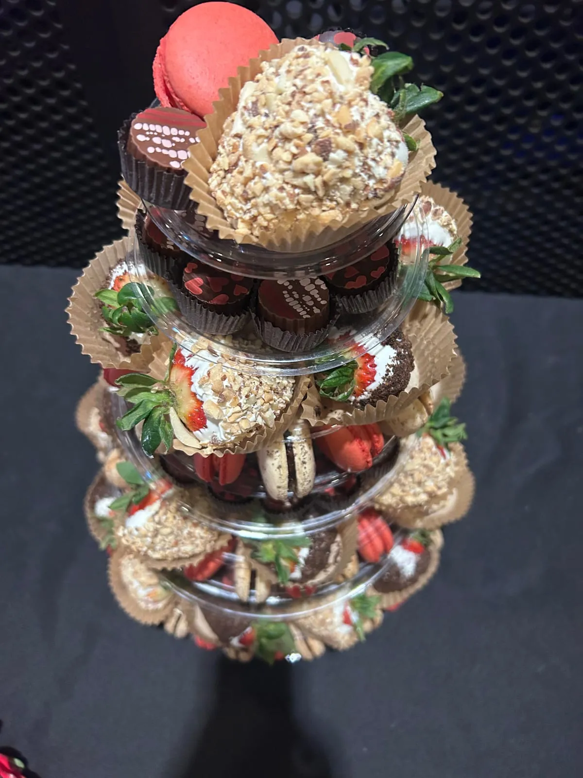 A close-up of an Event Tower with chocolate-dipped strawberries and a truffle