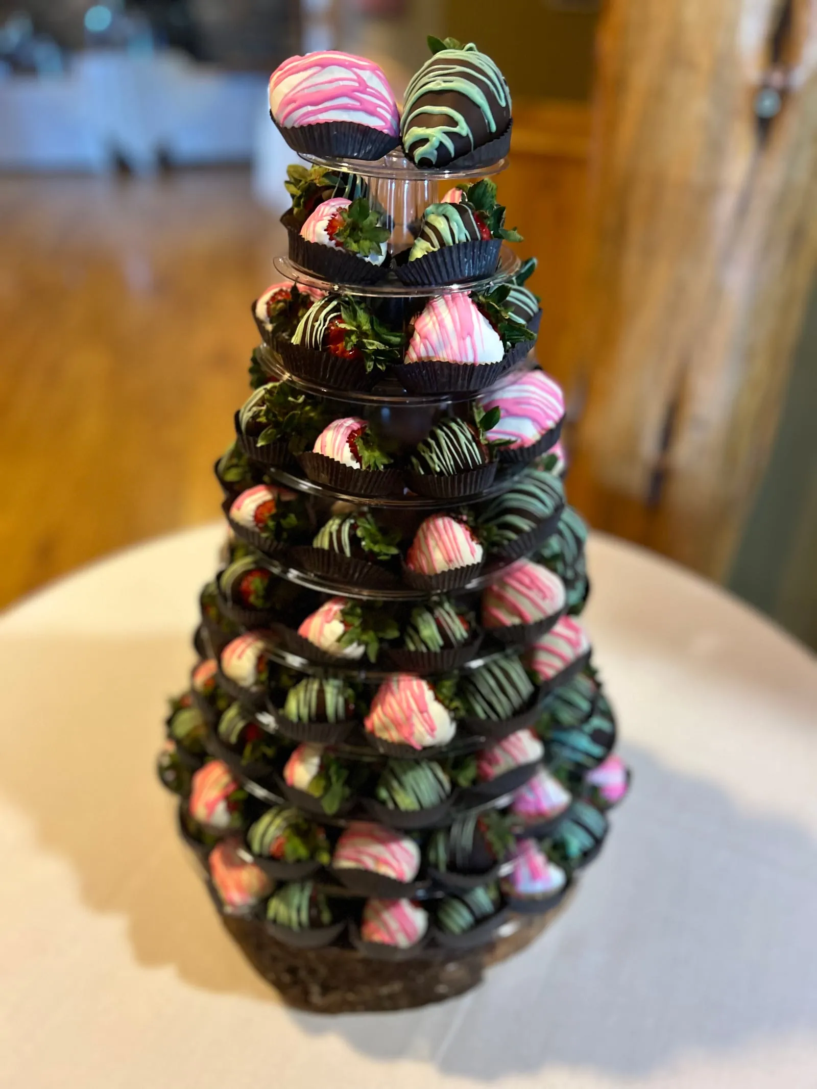 A tower of chocolate-dipped strawberries drizzled in pink and green