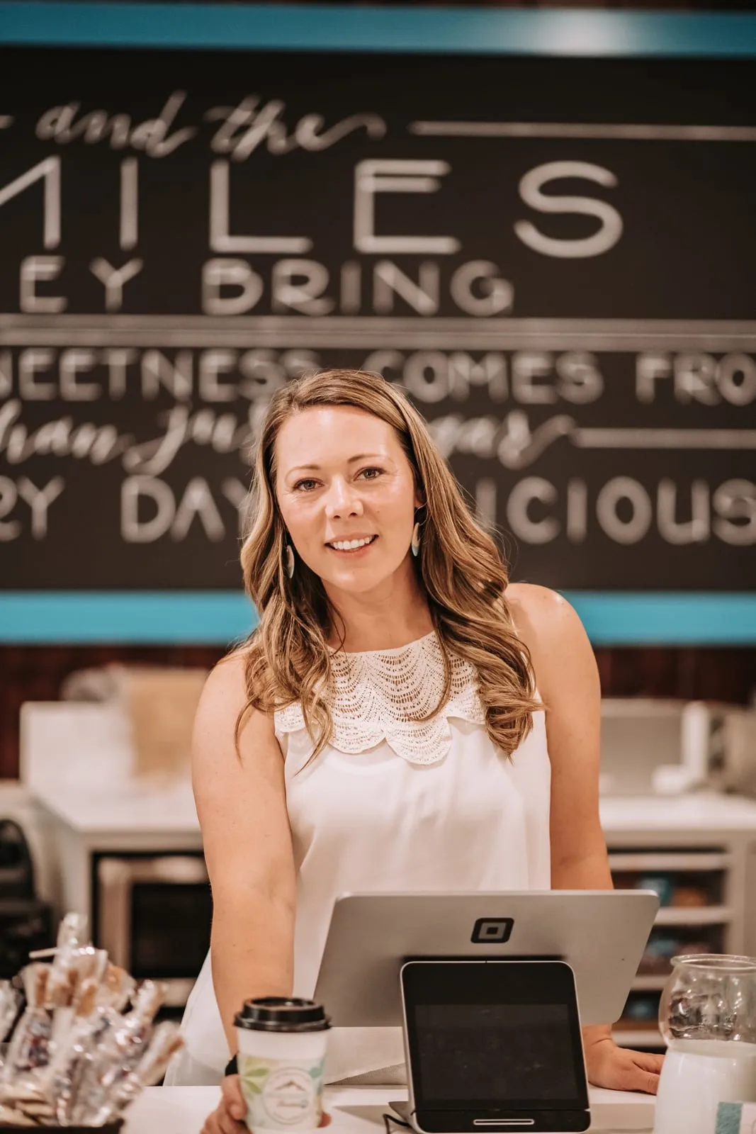 The owner smiling behind the High Desert Chocolates counter