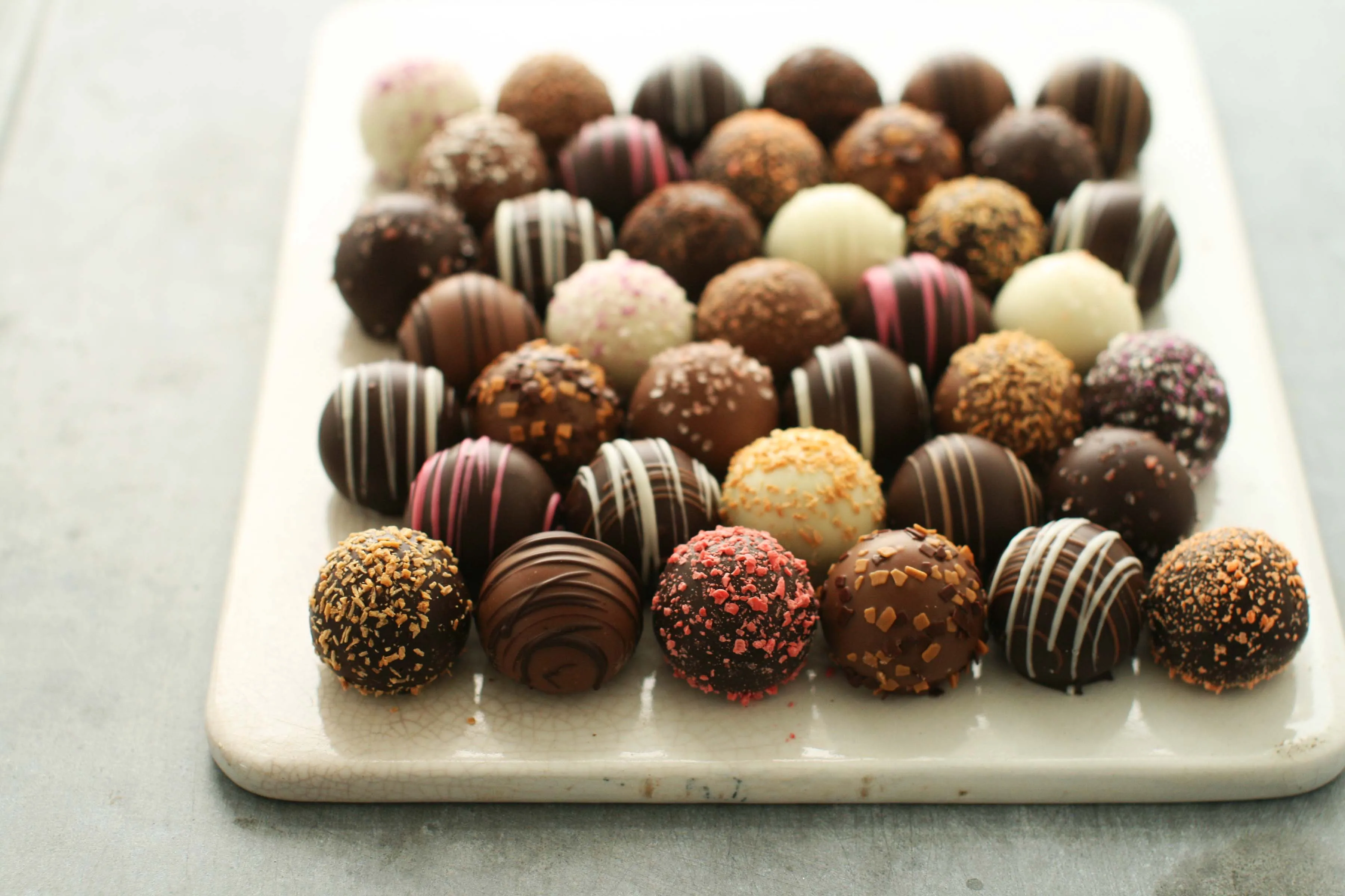 A large platter of approximately 40 hand-rolled truffles in varied finishes